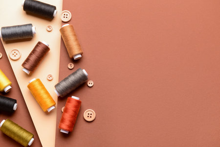 Composition with thread spools and buttons on color background