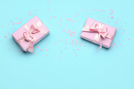 Gift boxes with beautiful bows and confetti on blue backgroundの写真素材