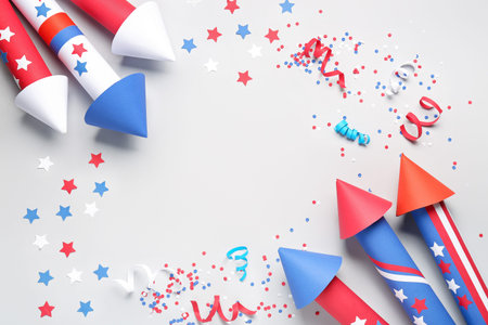 Frame made of firework rockets, serpentine and confetti for Independence Day on white background