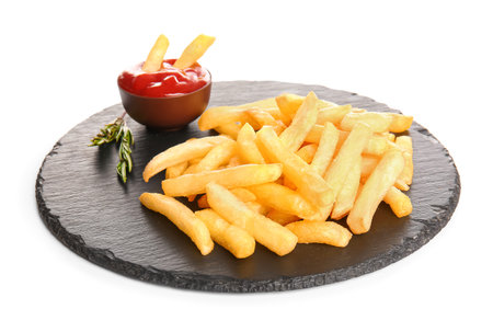 Slate board of tasty french fries and ketchup on white background