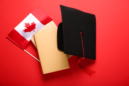 Flag of Canada with graduation hat and books on red backgroundの写真素材