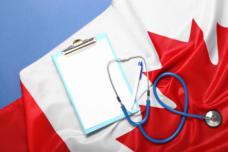 Clipboard with stethoscope and flag of Canada on blue backgroundの写真素材