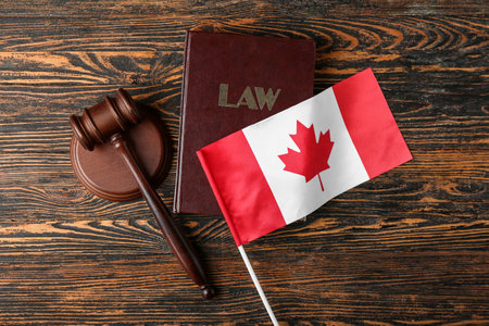 Flag of Canada with law book and judge's gavel on wooden backgroundの写真素材