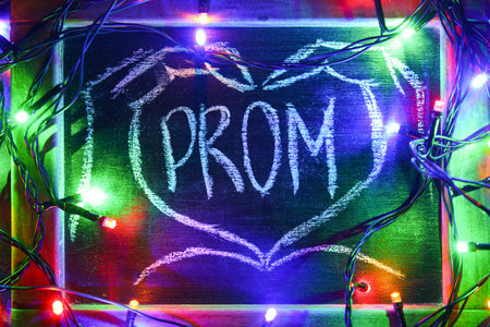 Chalkboard with word PROM and glowing lights on dark backgroundの写真素材