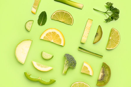 Composition with different fresh fruits and vegetables on green backgroundの写真素材