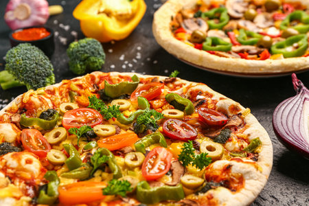 Vegetables pizzas with ingredients on dark backgroundの写真素材