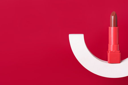 Decorative plaster podium and lipstick on red backgroundの写真素材