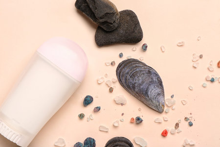 Deodorant with shells, stones and sea salt on beige background
