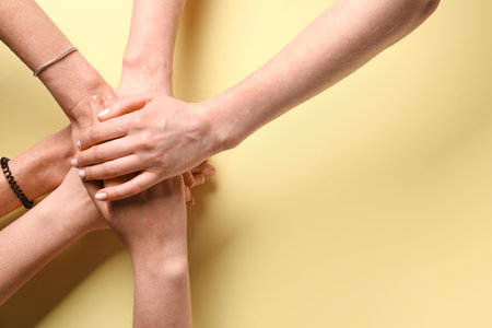 People putting hands together on yellow background, top view. friendship conceptの写真素材
