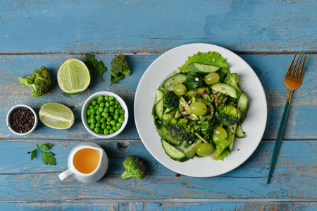 Board with plates of salad and ingredients on blue wooden backgroundの写真素材