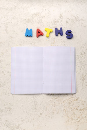 Blank copybook pages and text MATHS on white grunge background