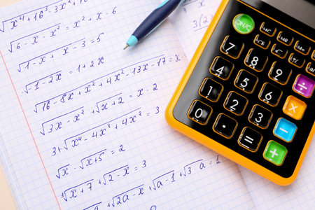 Copybook with maths formulas, calculator and pen, closeupの写真素材