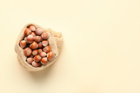 Sack bag with shelled hazelnuts on beige backgroundの写真素材
