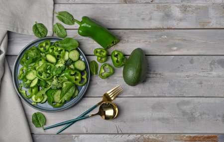 Plate of salad with green vegetables and ingredients on gray wooden backgroundの写真素材