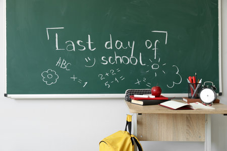 Text LAST DAY OF SCHOOL with drawings on blackboard in classroomの写真素材