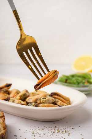 Plate with pickled mussels and bowl of seaweed salad on white backgroundの写真素材