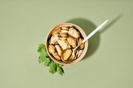 Bowl with pickled mussels on green backgroundの写真素材