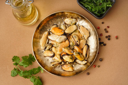 Plate with pickled mussels and bowl of seaweed salad on brown background