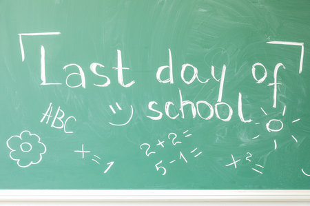 Text LAST DAY OF SCHOOL with drawings on blackboardの写真素材