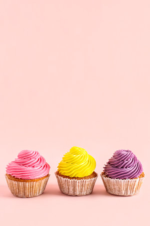Tasty colorful cupcakes on pink backgroundの写真素材