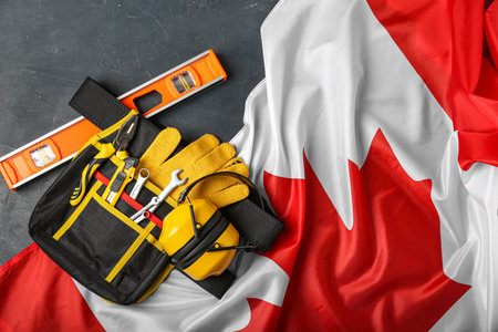 Bag with builder's tools and flag of Canada on dark backgroundの写真素材