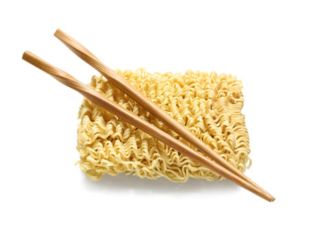 Raw instant noodles and wooden chopsticks on white backgroundの写真素材
