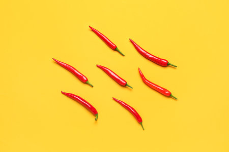 Fresh hot chili peppers on yellow backgroundの写真素材