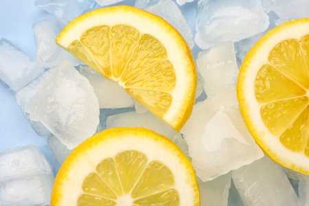 Sliced fresh lemon and ice cubes on blue backgroundの写真素材