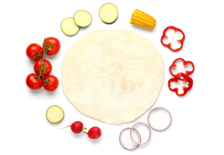 Raw dough and ingredients for preparing vegetable pie on white backgroundの写真素材