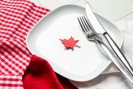 Table setting with paper maple leaf on white tile background, closeup. Canadian flag conceptの写真素材
