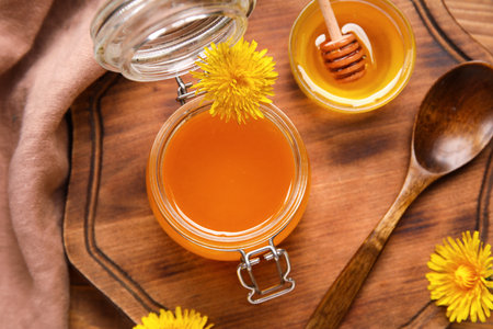 Jar and bowl with dandelion honey as background, closeupの写真素材