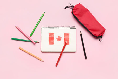 Notebook with drawn Canadian flag, pencils and case on pink backgroundの写真素材