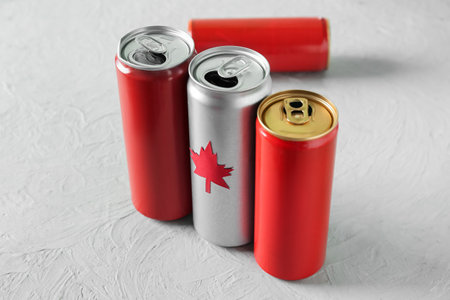 Cans of drink with maple leaf on gray table, closeup. Canadian flag conceptの写真素材