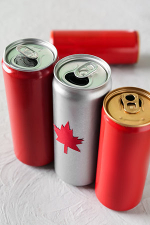 Cans of drink with maple leaf on gray table, closeup. Canadian flag conceptの写真素材