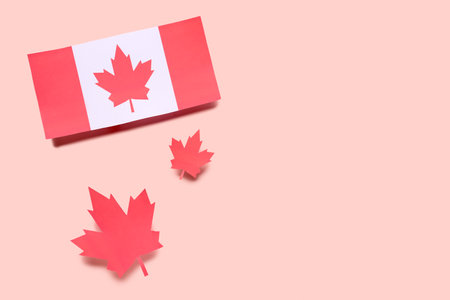 Flag of Canada with paper maple leaves on pink backgroundの写真素材