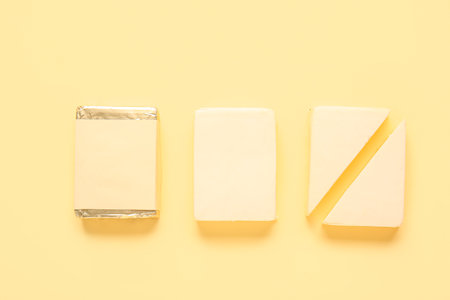 Sliced processed cheese on yellow backgroundの写真素材