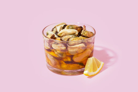 Glass bowl with pickled mussels on pink backgroundの写真素材