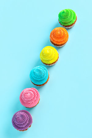 Tasty colorful cupcakes on blue backgroundの写真素材