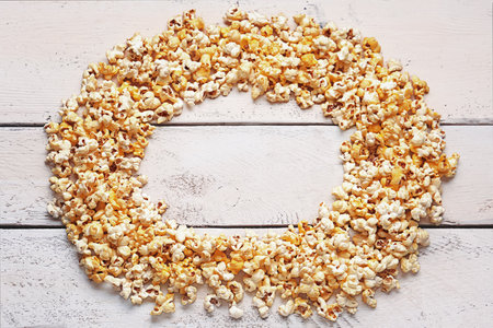 Frame made of crispy popcorn on white wooden backgroundの写真素材