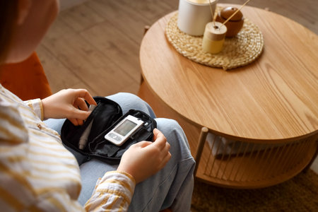 Woman with diabetes measuring blood sugar level at home
