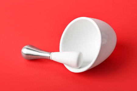 Mortar and pestle on red backgroundの写真素材