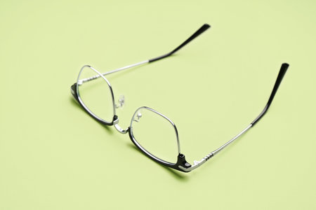 Stylish modern eyeglasses on pale green backgroundの写真素材