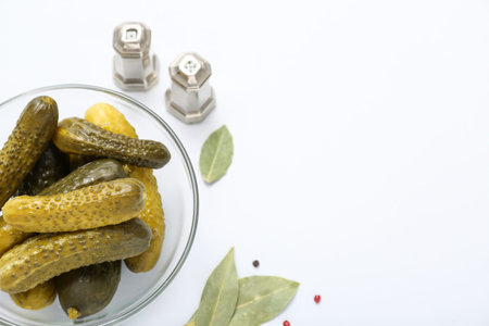 Bowl of tasty canned cucumbers with spices on white backgroundの写真素材