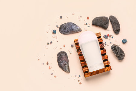 Deodorant with shells, stones and sea salt on beige background