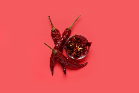 Bowl with sliced chili peppers on red background