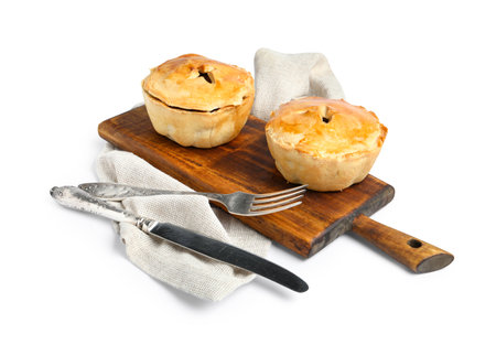 Wooden board with tasty meat pot pies on white backgroundの写真素材
