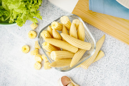 Bowl with tasty canned corn cobs on light backgroundの写真素材