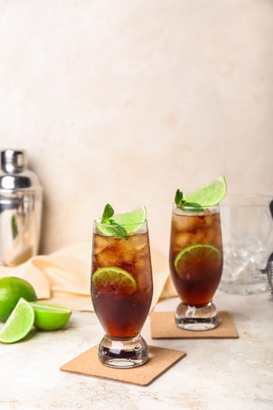 Glasses of cold Cuba Libre cocktail on light backgroundの写真素材