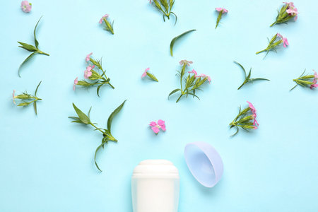 Deodorant bottle and flowers on blue backgroundの写真素材