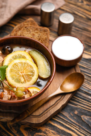 Bowl of tasty Hodgepodge soup with sour cream on wooden backgroundの写真素材